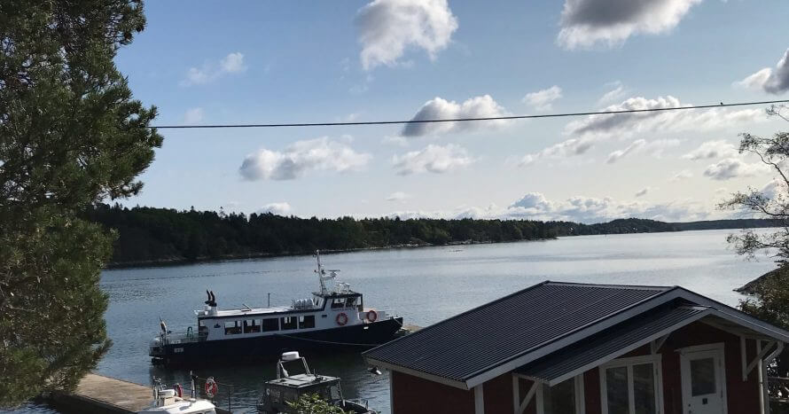 Solen lyser på en röd stuga på ön Idskär
